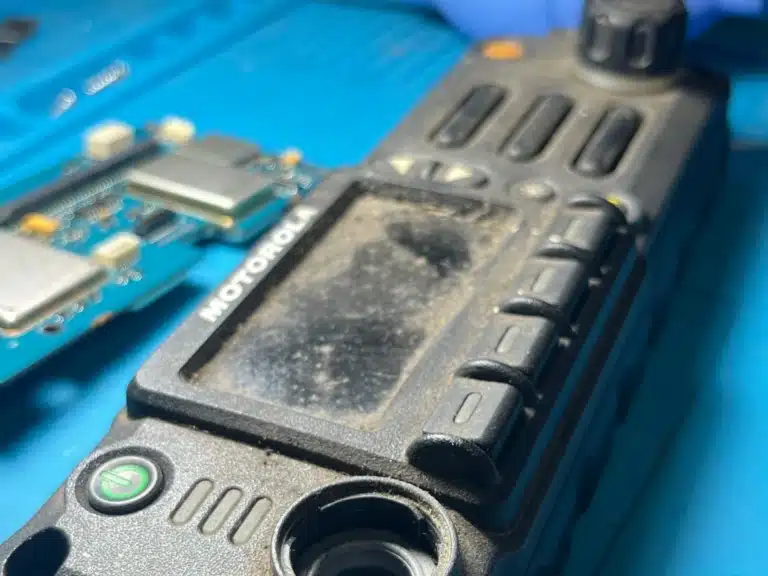 Frente de radio móvil Motorola con suciedad acumulada antes del mantenimiento