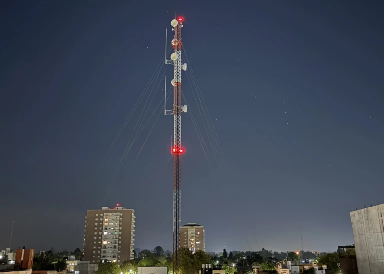 Torre de repetición con antenas y balizas encendidas de noche