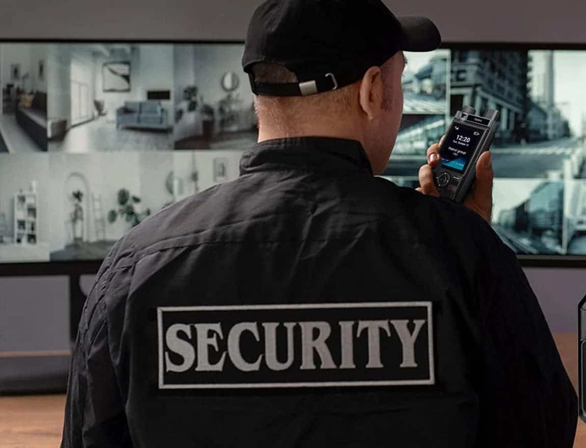 Supervisor de seguridad privada con radio PoC Hytera frente a los monitores de la central