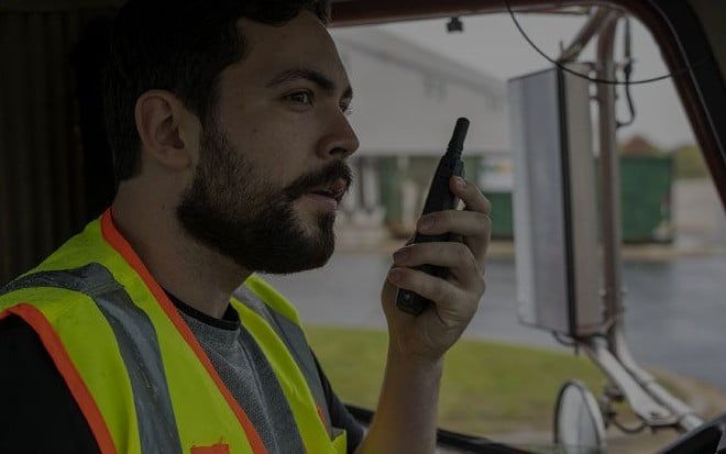 Chofer de camión hablando por radio Motorola desde la cabina
